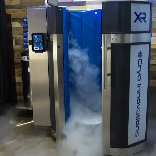 Cryo Innovations whole-body cryotherapy chamber with door open and cold nitrogen fog pouring out